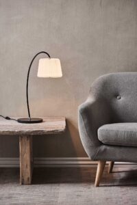 LE KLINT Snowdrop bordlampe med elegant buet stel og håndfoldet plisseret skærm, der skaber et blødt og behageligt lys.