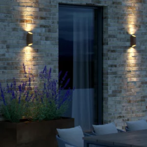 Nordlux Nico Round udendørslampe, placeret på en terrasse, og giver et varmt og funktionelt lys.
