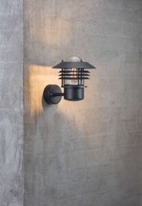 Nordlux Vejers væglampe i klassisk, rustikt design, perfekt til stemningsfuld og funktionel udendørsbelysning.