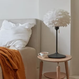 UMAGE Eos bordlampe med blød skærm af gåsefjer, der skaber en varm og hyggelig atmosfære.