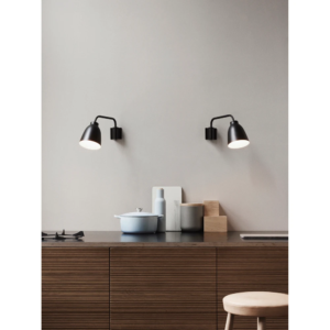 Sort Caravaggio væglampe fra Fritz Hansen monteret over en køkkenbordplade i et nordisk designhjem.